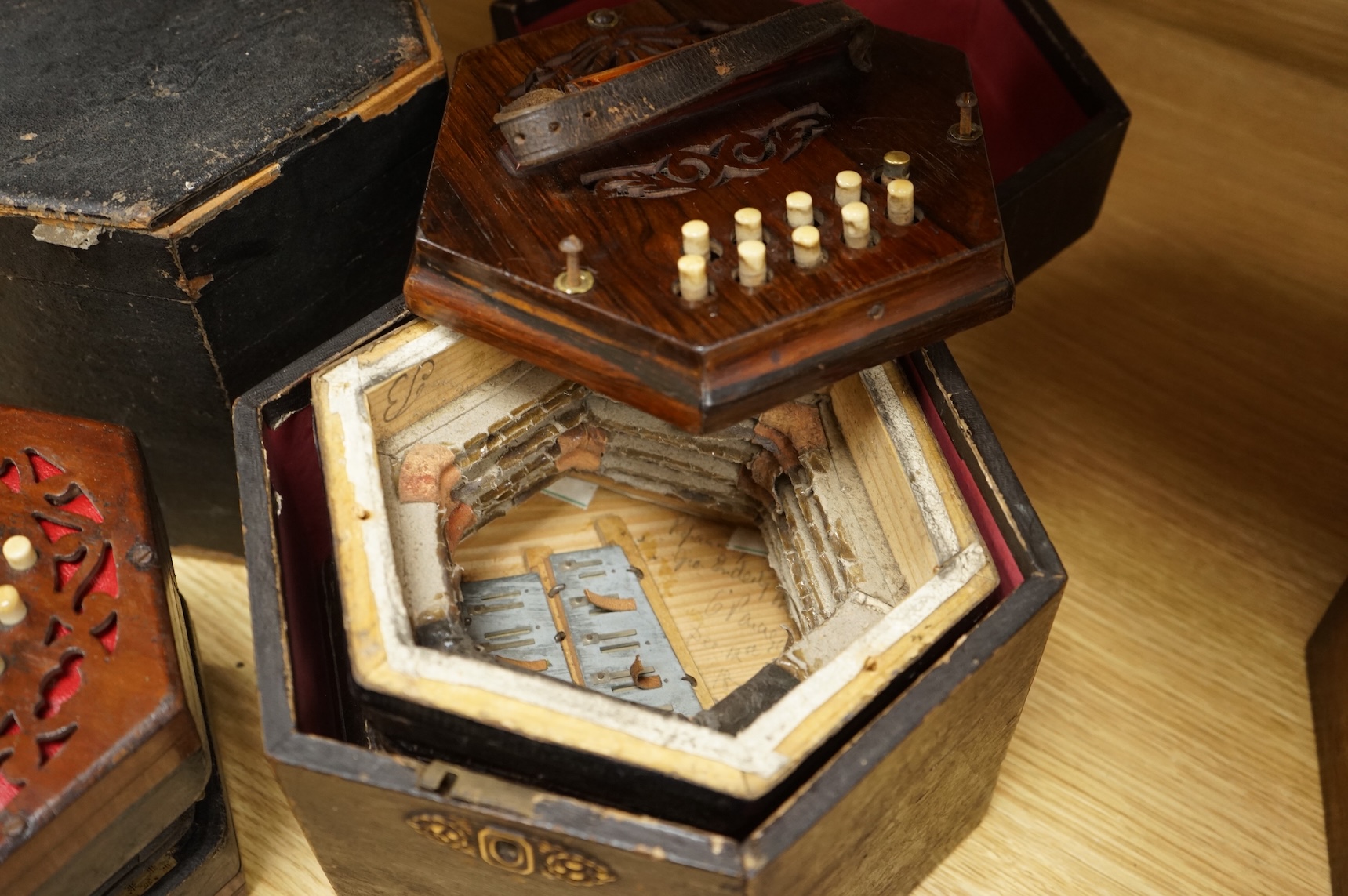 Two cased concertinas; one in mahogany with original paper label for Lachenal & Co., London, the other in rosewood (a.f.)